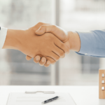 Stretta di mano tra due professionisti in un ufficio moderno, simbolo di passaggio generazionale e donazione d’azienda ai figli senza imposte, secondo le regole dell’Agenzia delle Entrate.